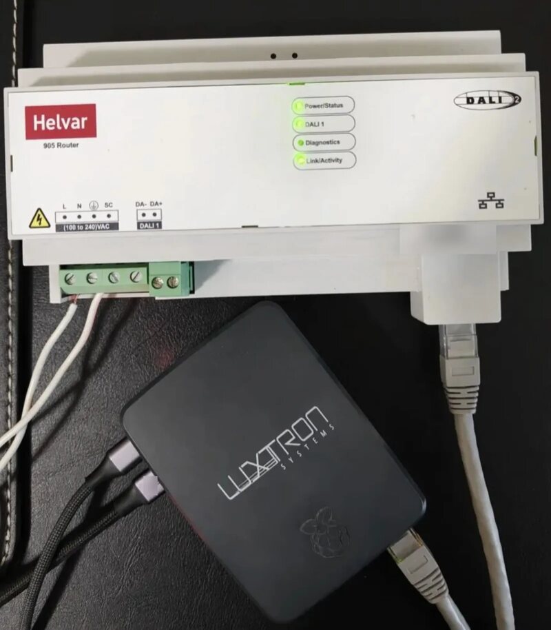BeamEdge unit, a small black Luxtron box, connected by network cable to a Helvar DALI router on a wall