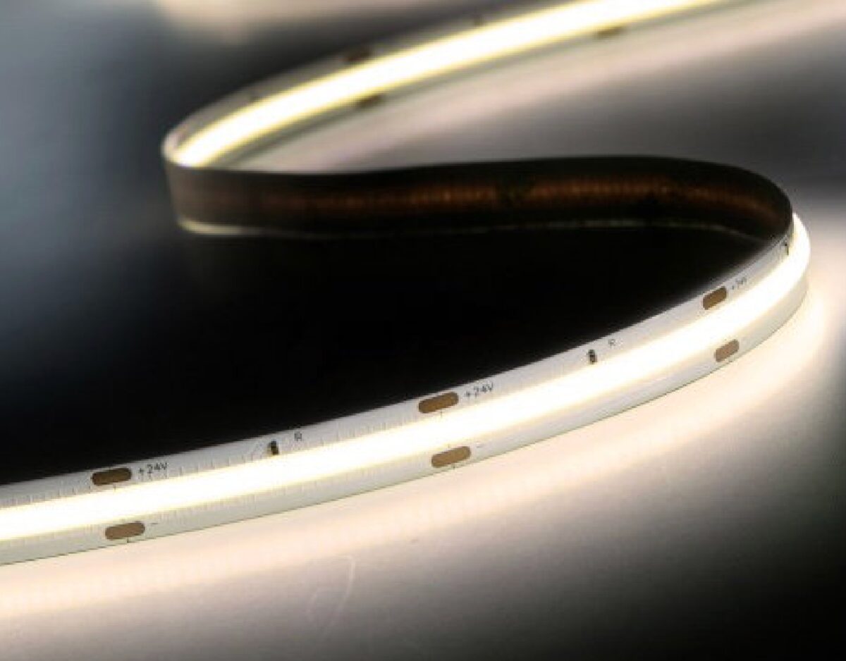 Lit COB.flex strip curling across a dark surface, showing a continuous line of light with no visible LED dots